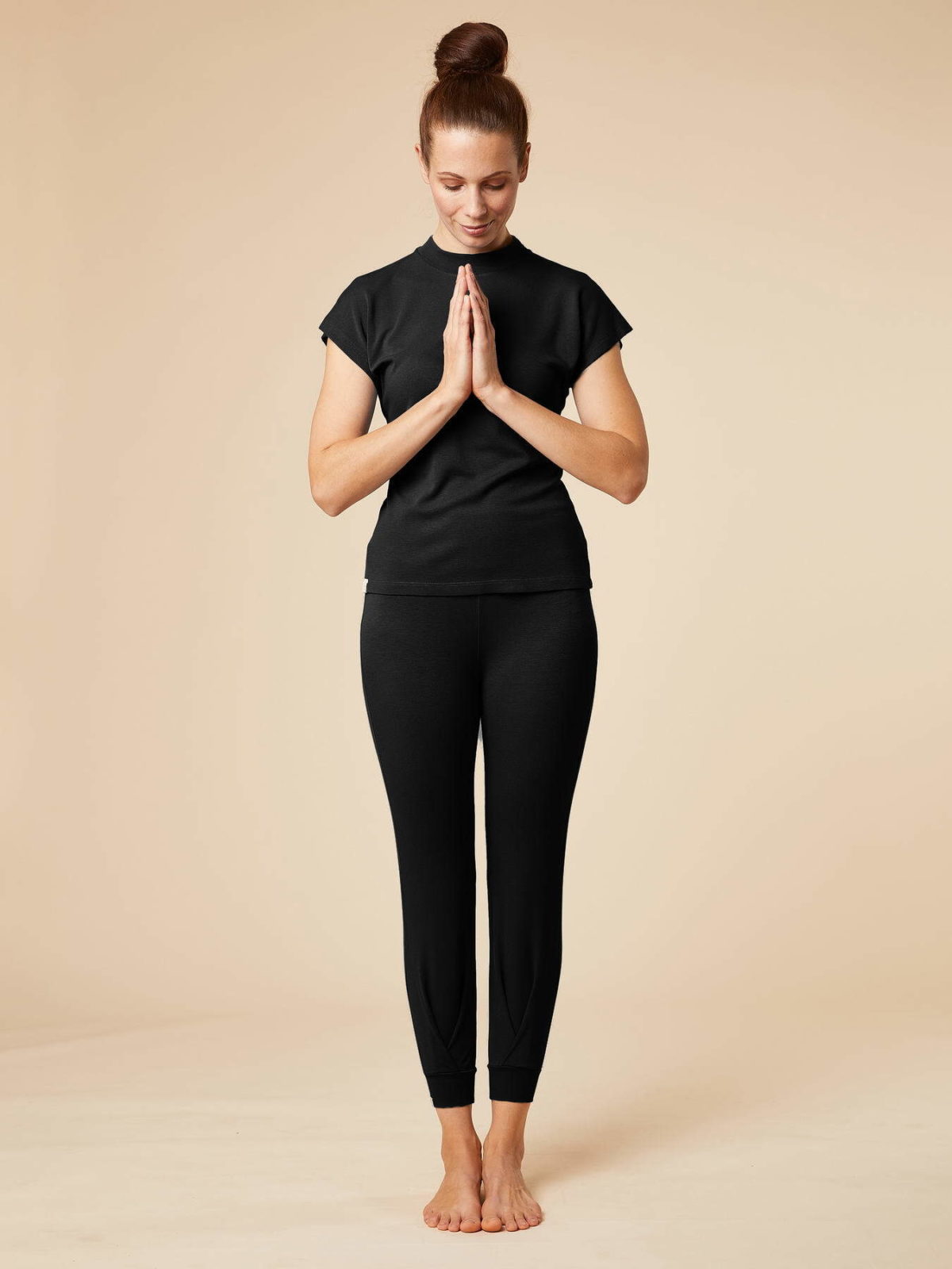 Frontansicht des Yoga-Outfits bestehend aus der Yoga-Hose Tara und dem Stehkragen-Shirt Balaga in Schwarz