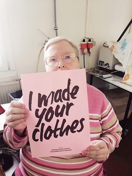 Frau hält Poster mit "I made your clothes" hoch