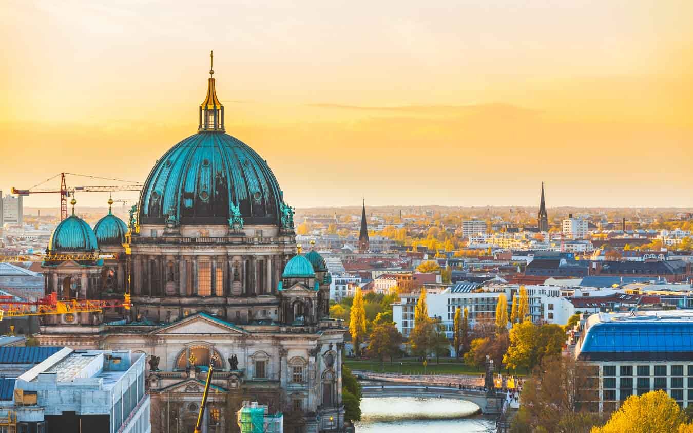 Berlin aerial view at sunset. Berlin Cathedral dome and cityscape. Golden light over Berlin rooftops in the late afternoon. Travel and architecture concepts